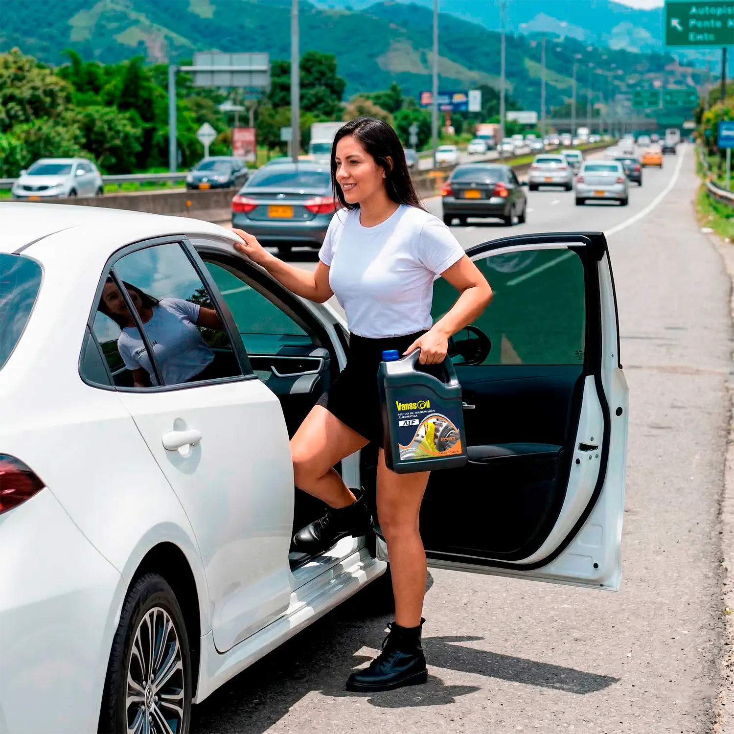 mujer con galon atf subiendose a carro en carretera colombia
